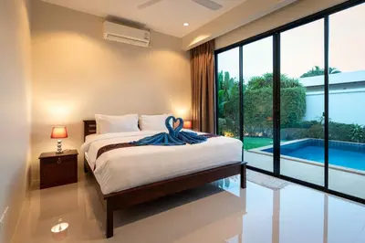 a bedroom with a bed and a view of a pool at Andaman 3br Private Pool Villa in Rawai Beach