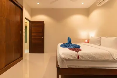 a bedroom with a bed with a blue towel on it at Andaman 3br Private Pool Villa in Rawai Beach