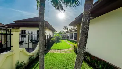 a view of the yard of a house with palm trees at Garden bungalows 4br with private pool in Rawai Beach
