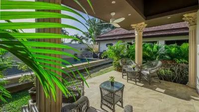 a patio with chairs and tables on a house at Garden bungalows 4br with private pool in Rawai Beach