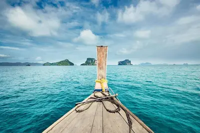 a boat on the water with islands in the background at Garden bungalows 4br with private pool in Rawai Beach