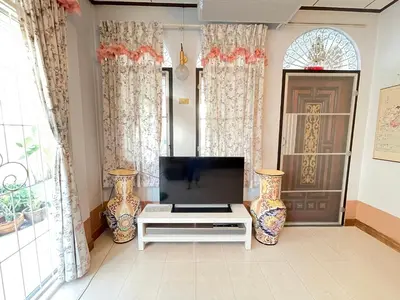 a living room with a tv and two vases at Lotus House in Ban Lo Long