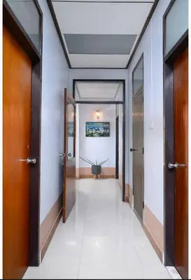 a hallway with doors and a plant in the middle at Lotus House in Ban Lo Long