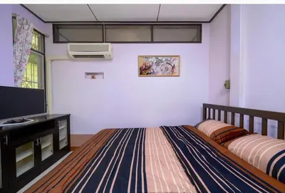 a bedroom with a bed and a flat screen tv at Lotus House in Ban Lo Long
