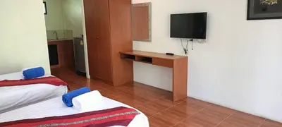 a hotel room with two beds and a television at Baan Suan Villas Resort in Ban Suan
