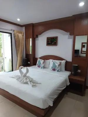 a bedroom with a bed with a flower on it at AINNY Residence in Patong Beach