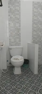 a bathroom with a toilet and a tile floor at AINNY Residence in Patong Beach