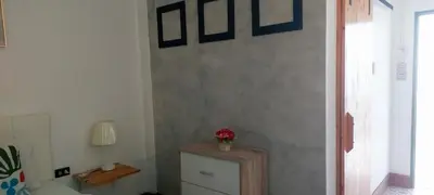 a room with a wall with pictures on the wall at AINNY Residence in Patong Beach