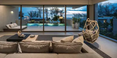 a living room with a couch and a large window at Veyla Natai Residences - Luxury Pool Villa in Khok Kloi