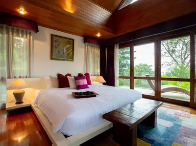 a bedroom with a white bed with a table on it at Infinity View by Elite Havens in Kata Beach