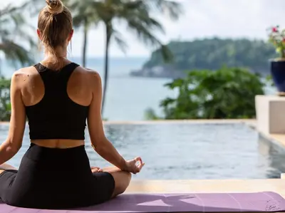 a woman doing yoga by a pool at Infinity View by Elite Havens in Kata Beach