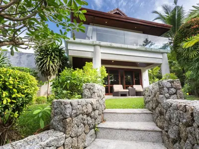 a house with a stone wall and a stairway at Infinity View by Elite Havens in Kata Beach