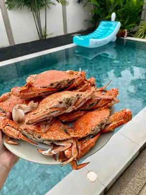 a plate of crabs on a table next to a pool at Private Pool Villa at Nai Harn 2 bedroom in Rawai Beach