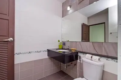 a bathroom with a toilet and a sink and a mirror at Private Pool Villa at Nai Harn 2 bedroom in Rawai Beach