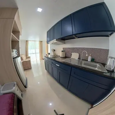 a kitchen with blue cabinets and a sink at The Kris Residence in Patong Beach