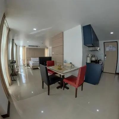a kitchen and living room with a table and chairs at The Kris Residence in Patong Beach