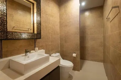 a bathroom with a sink and a toilet and a mirror at Oriental 3br private Pool Villa in Rawai Beach