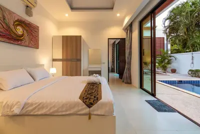 a bedroom with a bed and a swimming pool at Oriental 3br private Pool Villa in Rawai Beach