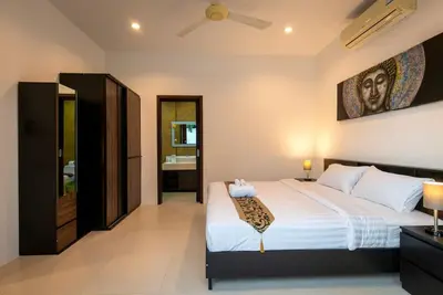 a bedroom with a bed and a painting on the wall at Oriental 3br private Pool Villa in Rawai Beach