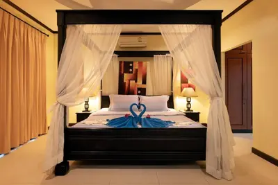 a bedroom with a bed with a blue ribbon on it at Villa Rodentia 3br pool Villa in Rawai Beach