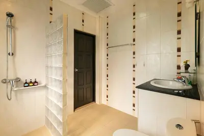a bathroom with a black door and a sink at Villa Rodentia 3br pool Villa in Rawai Beach