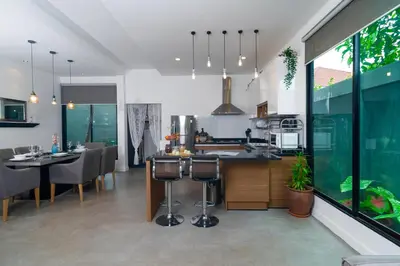 a kitchen and dining room with tables and chairs at Villa Charming - Lovely 2 bedrooms house with pool in Rawai Beach