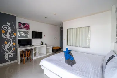 a bedroom with a bed with a blue item on it at Santi White House Patong in Patong Beach