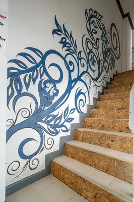 a wall with a blue and white painting on a staircase at Santi White House Patong in Patong Beach