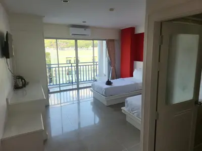 a hotel room with two beds and a balcony at Santi White House Patong in Patong Beach