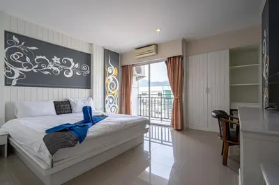 a bedroom with a bed and a balcony at Santi White House Patong in Patong Beach