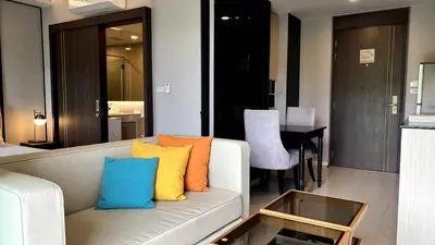 a living room with a couch with colorful pillows at Mida Grande Apartment with Rooftop Pool near Surin Beach in Surin Beach