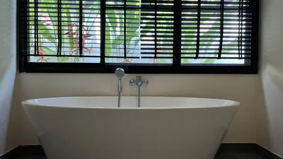 a bath tub in a room with a window at Plunge Tropic Pool Villa near Nai Harn Beach in Rawai Beach