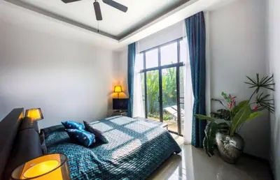 a bedroom with a bed with blue pillows and a window at Вилла с бассейном на Най Харн, 3 спальни G7 in Rawai Beach