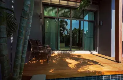 a patio with a chair and a large window at Вилла с бассейном на Най Харн, 3 спальни G7 in Rawai Beach