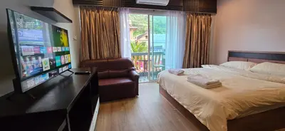 a bedroom with a bed and a flat screen tv at Taxim Boutique Hotel in Patong Beach