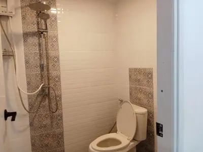 a bathroom with a toilet and a shower at Taxim Boutique Hotel in Patong Beach