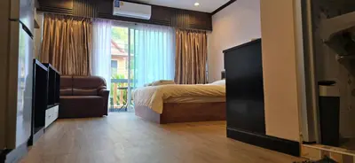 a bedroom with a bed and a large window at Taxim Boutique Hotel in Patong Beach