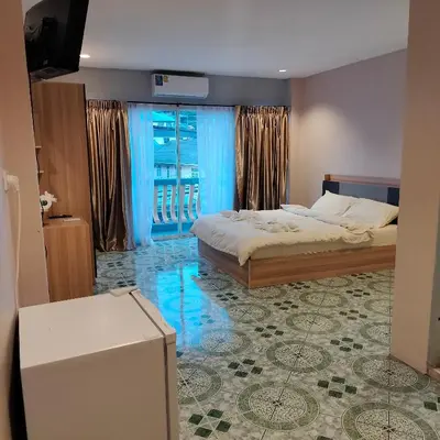 a bedroom with a bed and a large window at Taxim Boutique Hotel in Patong Beach