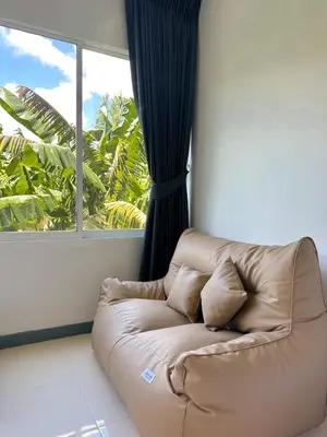 a brown couch in a room with a window at BAOBAB in Patong Beach