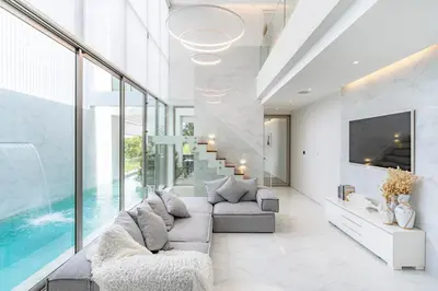 a living room with a couch and a tv at The Residence by Andaman Villa in Phuket Town