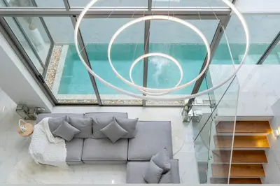 a living room with a couch and a large window at The Residence by Andaman Villa in Phuket Town