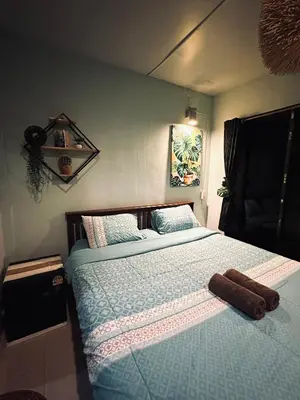 a bedroom with a bed with a blue comforter at MILD ROOM SEA VIEW ROOM FOR RENT in Phi Phi Don