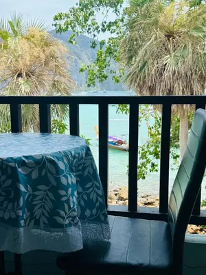 a table on a balcony with a view of the water at MILD ROOM SEA VIEW ROOM FOR RENT in Phi Phi Don
