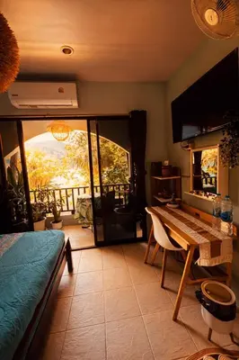a bedroom with a table and a view of a balcony at MILD ROOM SEA VIEW ROOM FOR RENT in Phi Phi Don