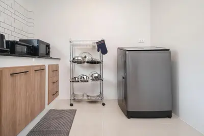 a kitchen with a refrigerator and a shelf with pots and pans at 2BR Homey townhome 350M walk to Kata Beach Fully equipped in Kata Beach