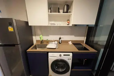 a small kitchen with a washing machine and a sink at The Base Central - Luxury Resort-Style Comfort in Ban Rangeng
