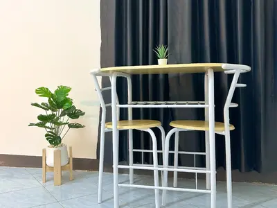 a table with two stools and a table with plants at MONTANA Hotel & Hostel Phuket in Karon Beach
