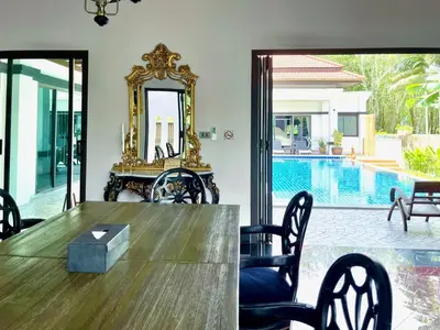 a dining room with a table and chairs and a mirror at Siam Jewel - Private pool villa in Bang Tao in Bang Tao Beach