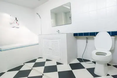 a bathroom with a white toilet and a mirror at Kai Mook House in Ban Ket Ho