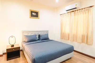 a bedroom with a bed with blue sheets and a window at Kai Mook House in Ban Ket Ho